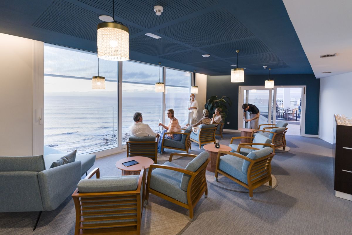 Personen sitzen in einer Lounge mit Blick auf das Meer in Puerto de la Cruz, Teneriffa.