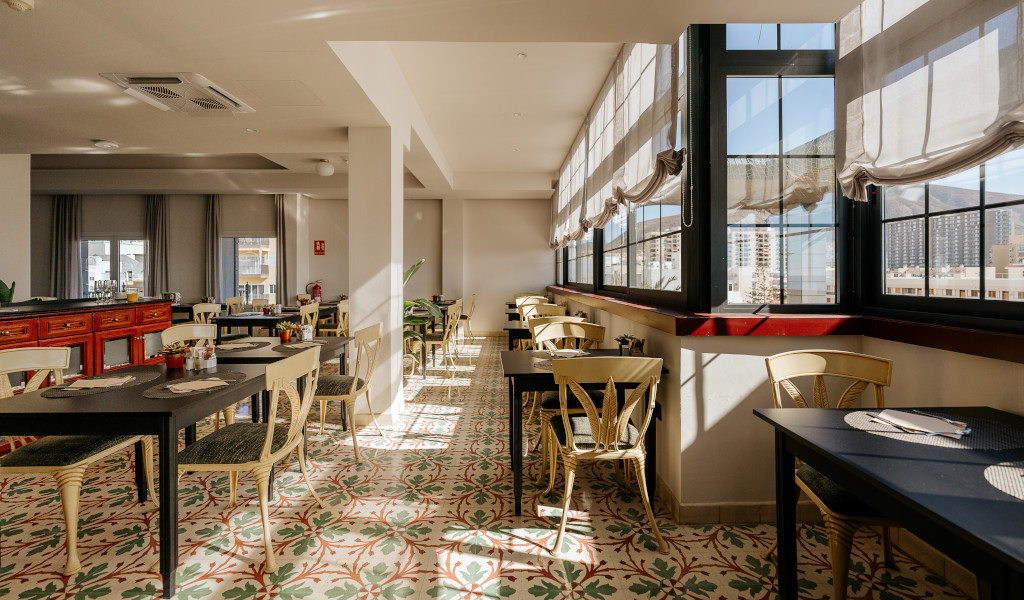Helles Restaurant mit Tischen, Stühlen und großen Fenstern in Santa Cruz de Tenerife.