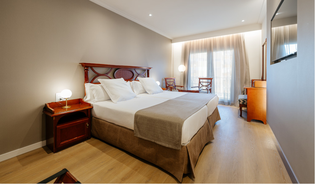 Zweibettzimmer in einem Hotel in Teneriffa mit Holzmöbeln und Tageslicht.