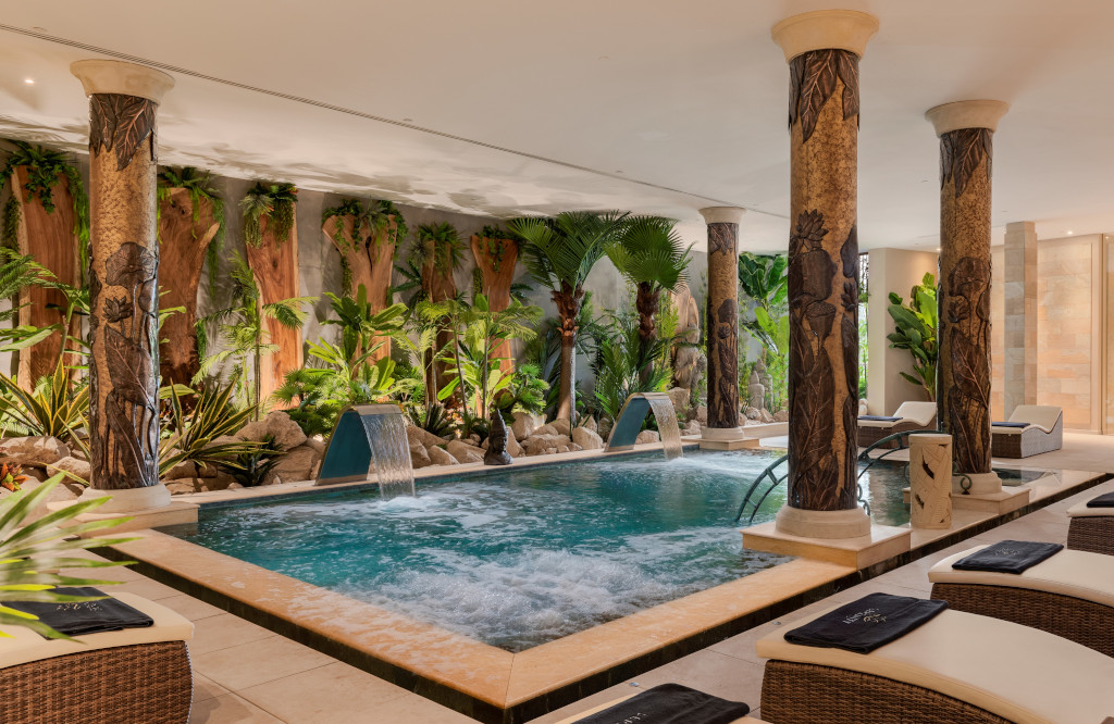 Innenpool mit Pflanzen und verzierten Säulen in einem Hotel in Teneriffa.