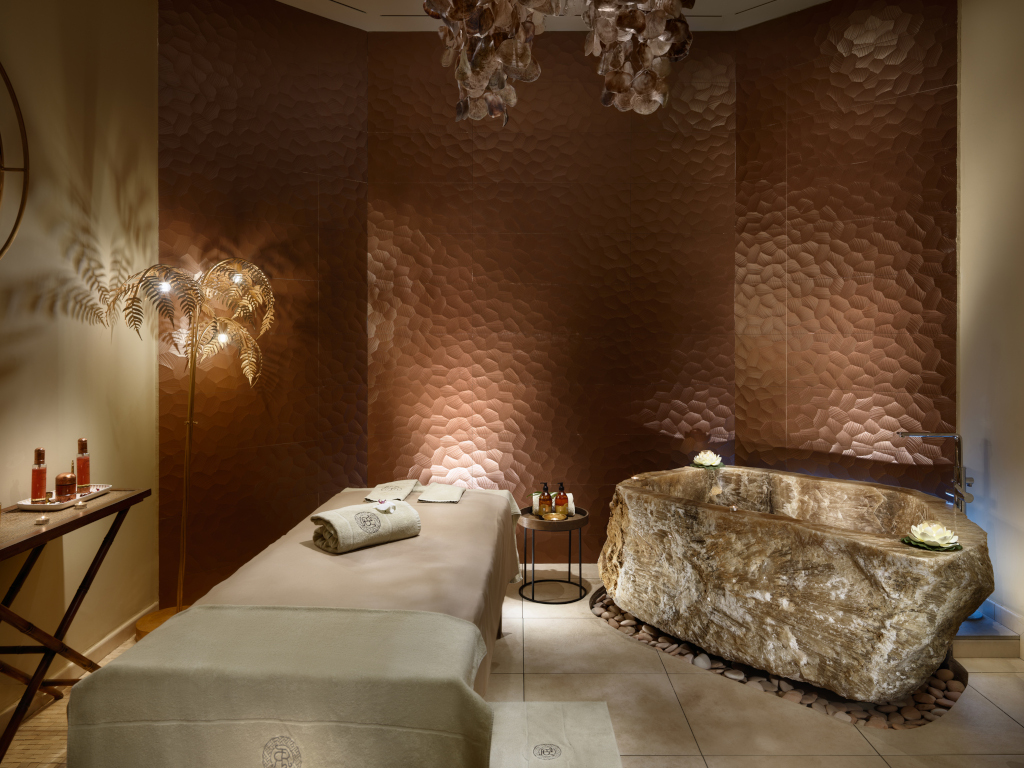 Spa-Raum mit Steinbadewanne und Massagetisch im Hotel in Teneriffa.