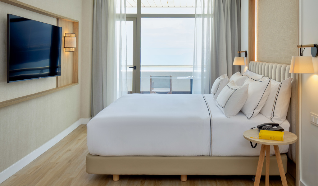 Modernes Hotelzimmer mit Bett, Fernseher und Balkonblick in Teneriffa.