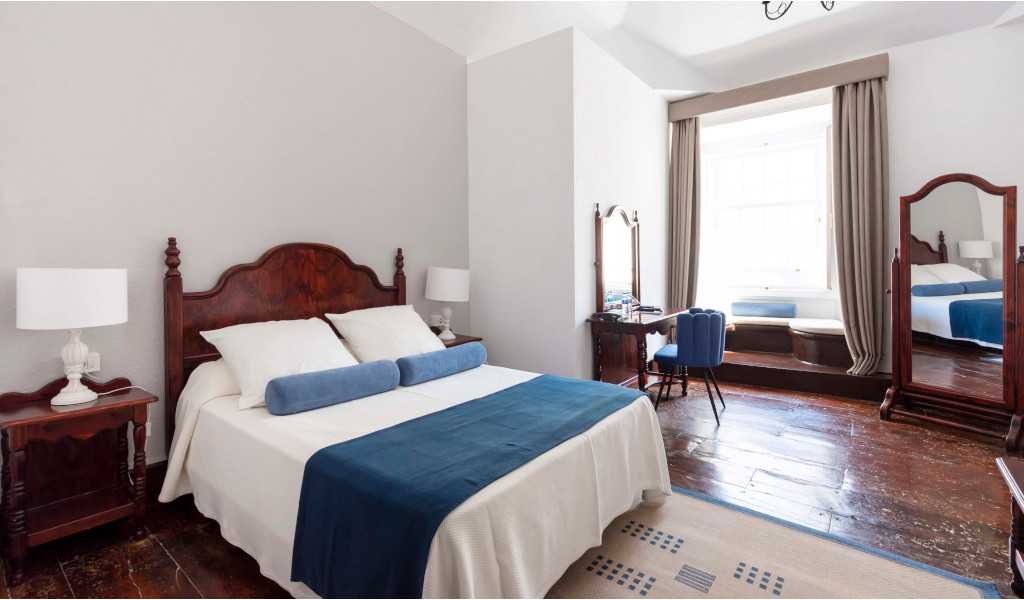 Schlafzimmer mit Doppelbett, Holzkommode und Spiegel in La Orotava, Tenerife.