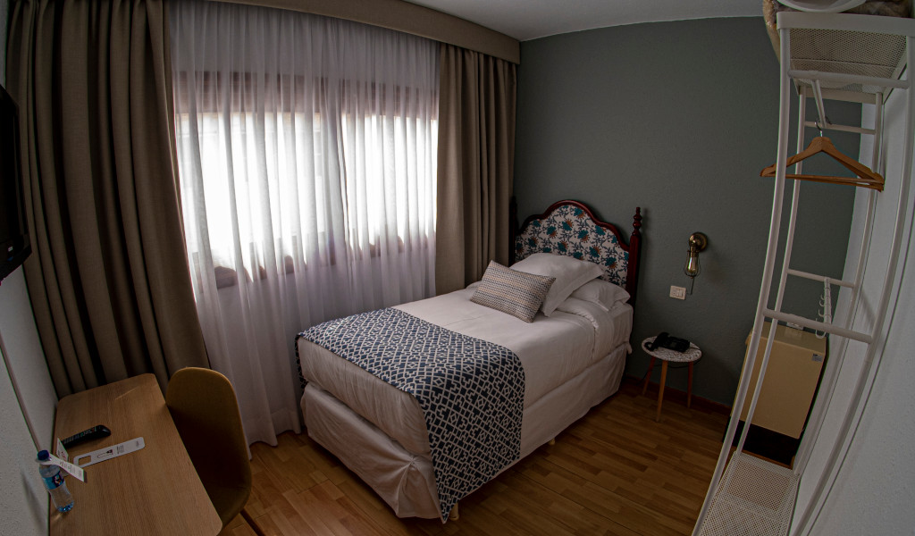 Einzelbettzimmer in Santa Cruz de Tenerife mit Schreibtisch und Kleiderständer.