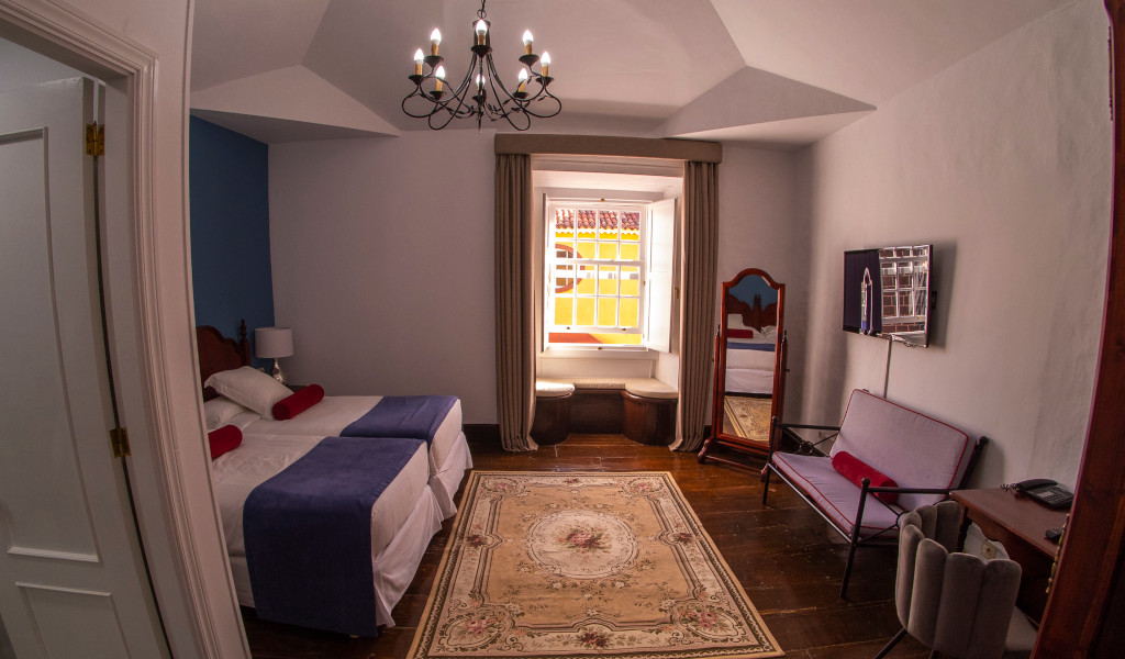 Ein Hotelzimmer in La Orotava, Teneriffa, mit Doppelbett, Fenster und Sitzbereich.