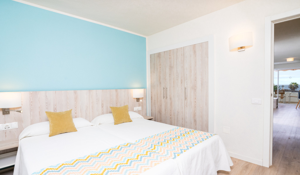 Zwei Betten in einem Zimmer in Tenerife, mit Zugang zu einem Balkon mit Meerblick.