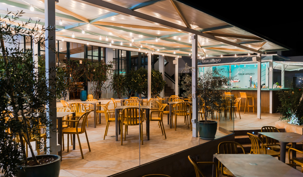Eine Terrasse mit gelben Stühlen bei Nacht in Guacamayo, Teneriffa.