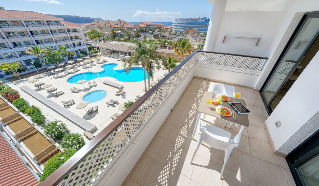 Blick vom Balkon auf den Poolbereich eines Resorts in Adeje, Teneriffa.