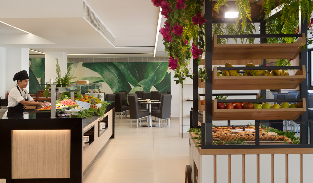 Koch in Restaurant in Teneriffa mit Obstbuffet und tropischen Pflanzen.