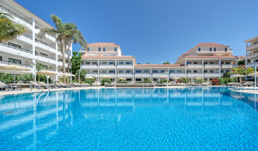 Großes Hotelgebäude mit Palmen und Pool in Puerto de la Cruz, Teneriffa.