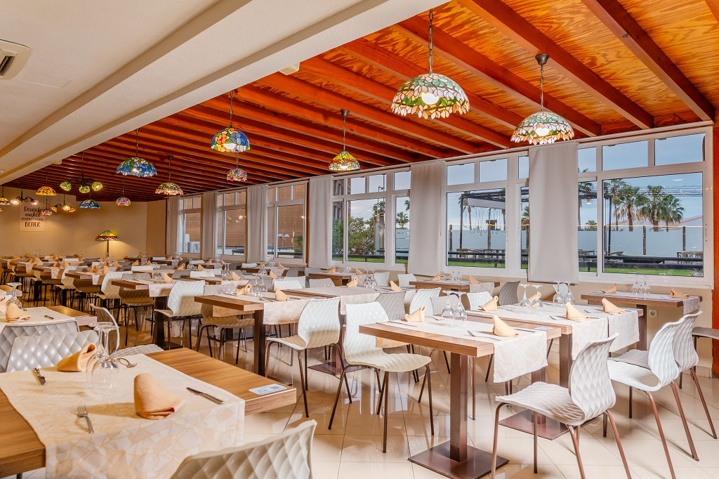 Großes Restaurant in Teneriffa mit Tischen, Stühlen und bunten Lampen.