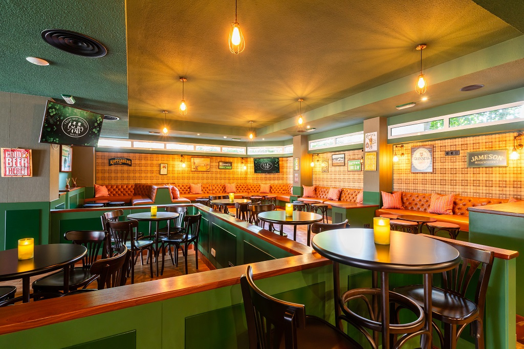 Gemütliche Bar mit runden Tischen, Holzmöbeln und warmem Licht in Tenerife.