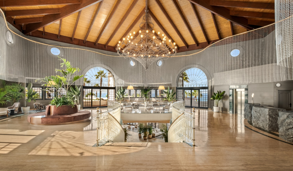 Große, elegante Hotellobby mit Pflanzen, Palmenblick und hochwertiger Innenarchitektur in Teneriffa.