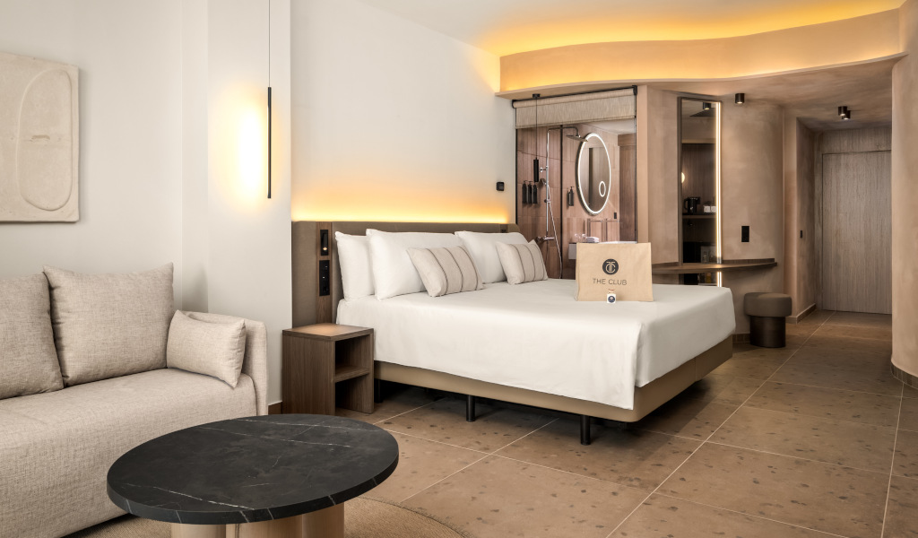 Modernes Hotelzimmer in Teneriffa mit Doppelbett, Sofa, Tisch und der Aufschrift The Club.