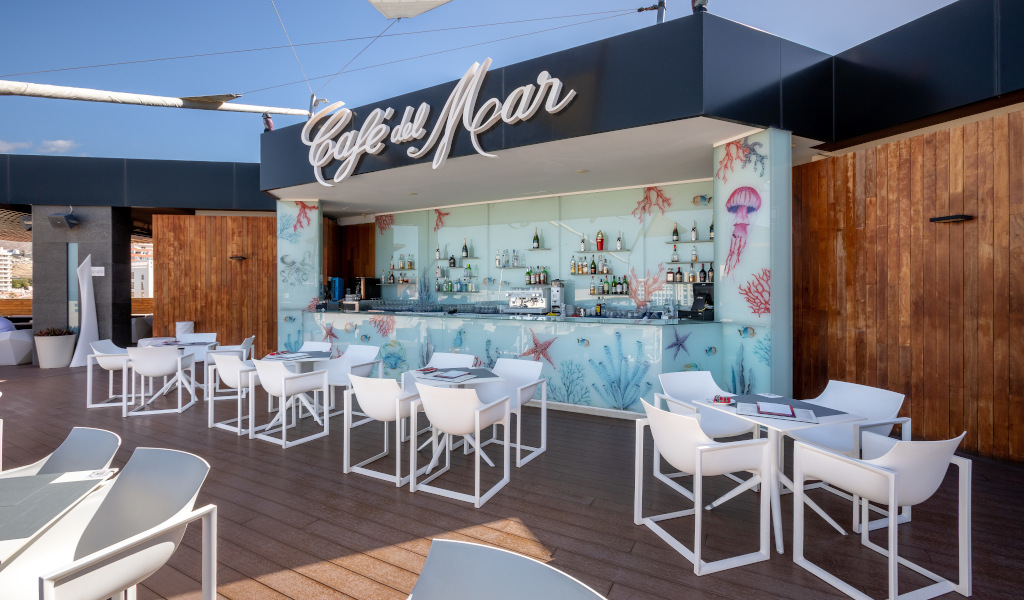Café del Mar Terrasse auf Teneriffa mit weißen Tischen und Stühlen.