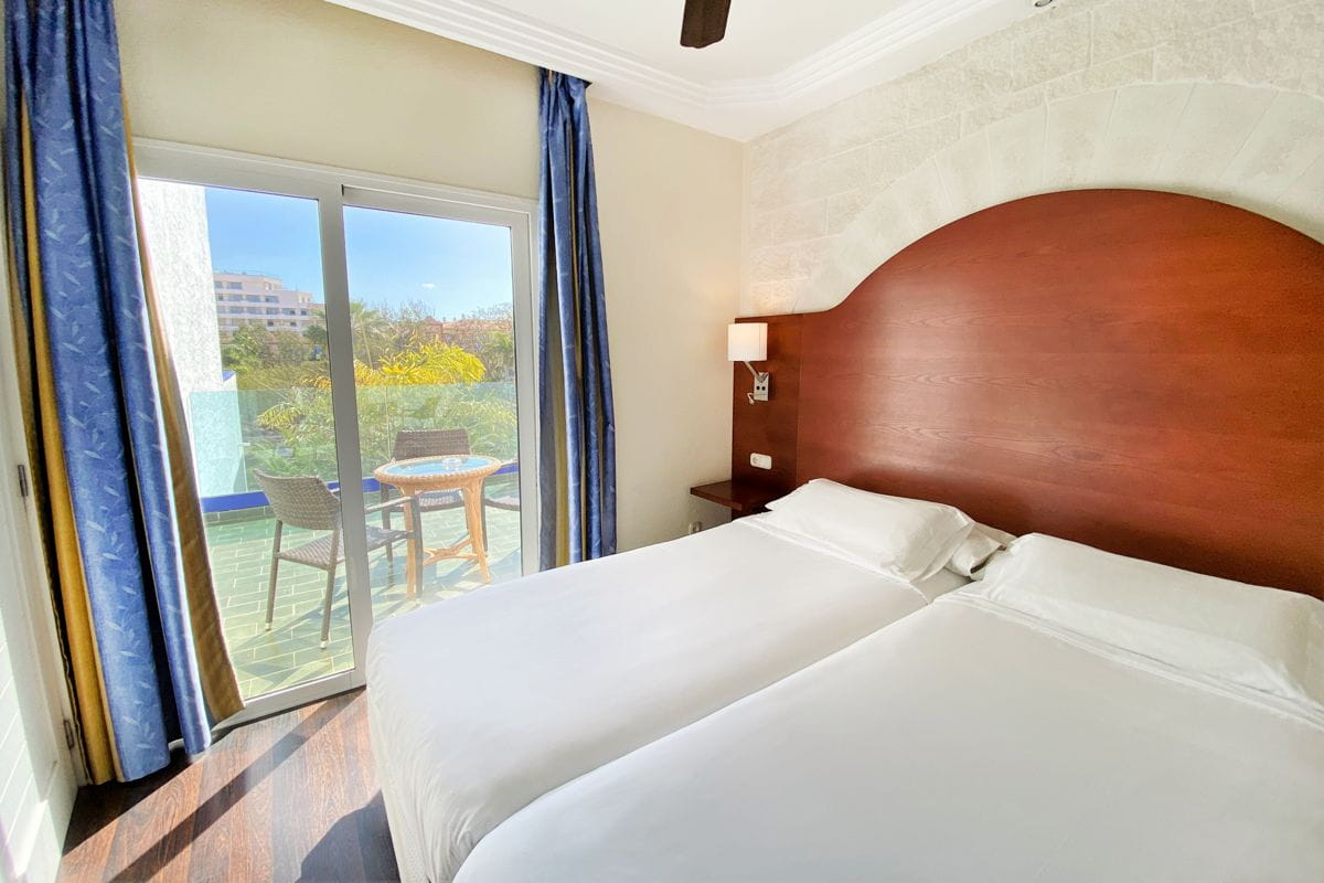 Zwei Einzelbetten in einem Hotelzimmer in Puerto de la Cruz mit Balkon und Tisch.