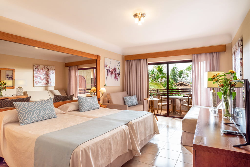 Hotelzimmer mit zwei Betten, Sofa, Tisch und Stühlen in Puerto de la Cruz, Teneriffa.