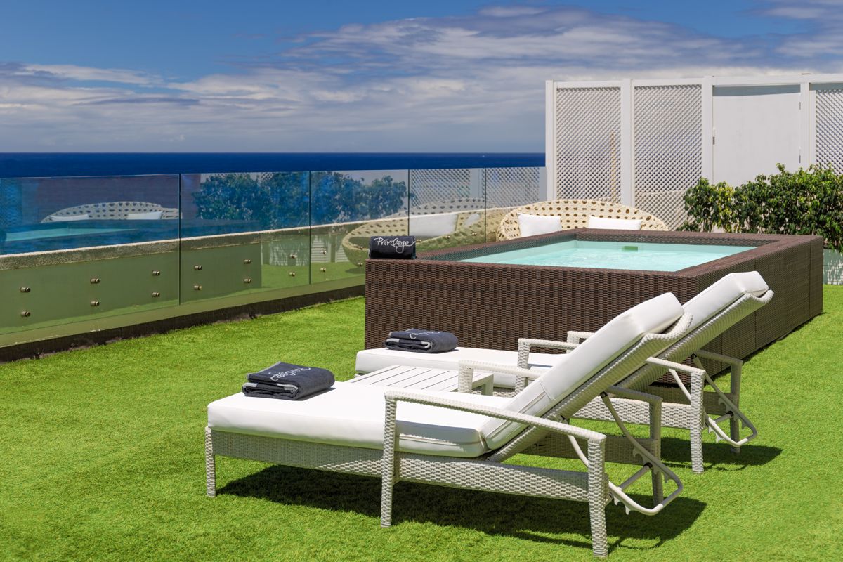 Liegestühle und Pool auf Terrasse mit Meerblick in Puerto de la Cruz, Teneriffa.
