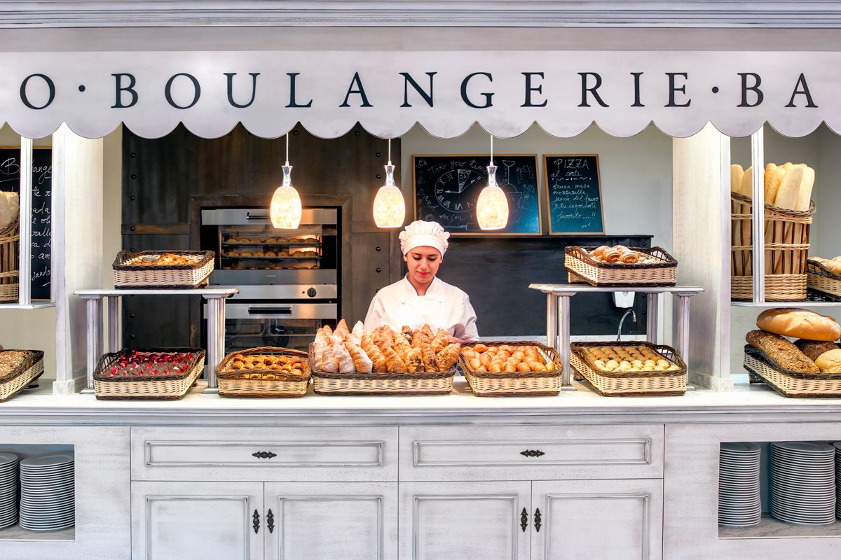Bäckerin hinter Theke mit Gebäck und Brot in Boulangerie in Puerto de la Cruz.