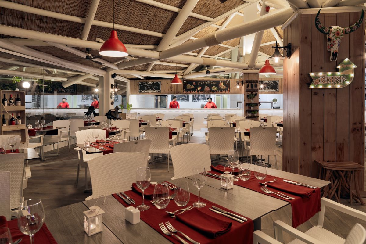 Restaurant in Costa Adeje, Tenerife mit gedeckten Tischen und Küchenbereich im Hintergrund.