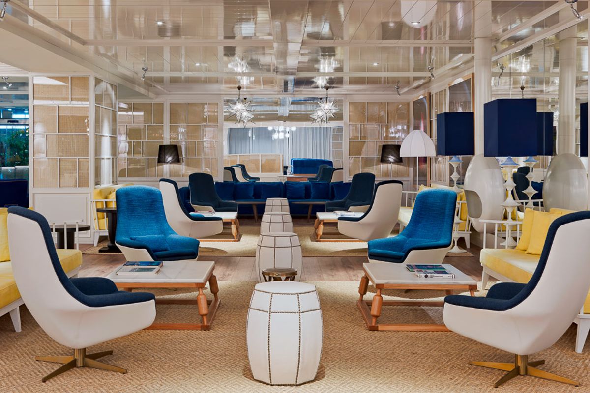 Moderner Aufenthaltsraum mit blauen und gelben Sesseln, angeordnet um Tische, in einem Hotel in Tenerife.