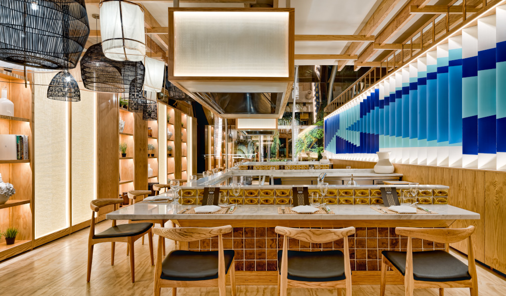 Moderne Restaurant-Innenansicht mit Holzmöbeln und blauen Akzenten in Tenerife.