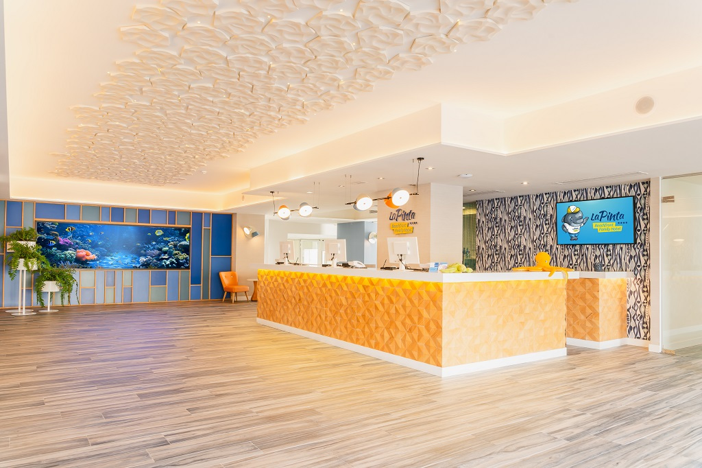 Rezeption des Hotels La Pinta in Teneriffa mit Aquarium und Logo.