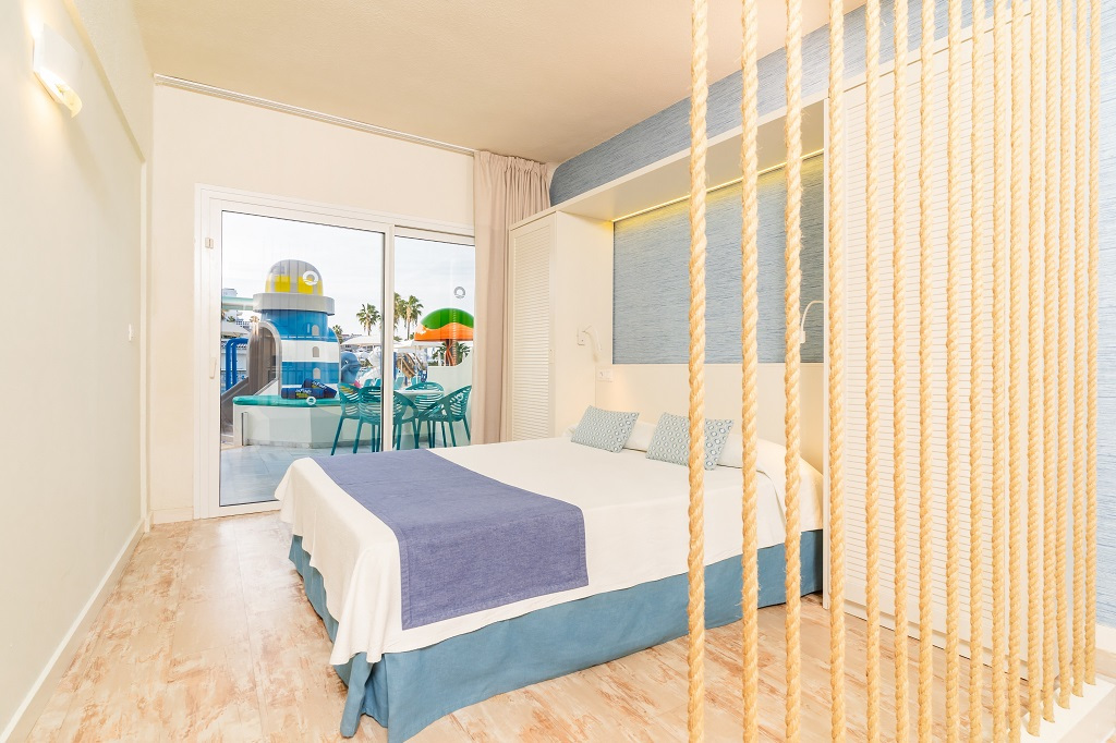Schlafzimmer mit Glaswand und Blick auf Spielplatz, Los Cristianos, Teneriffa.
