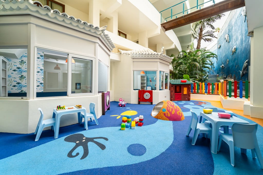 Kinderecke mit Tischen, Spielzeug und buntem Boden im Hotel auf Teneriffa.