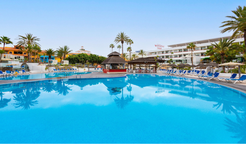 Poolbereich des Las Águilas Hotels in Puerto de la Cruz, Teneriffa, mit Liegestühlen und Palmen.