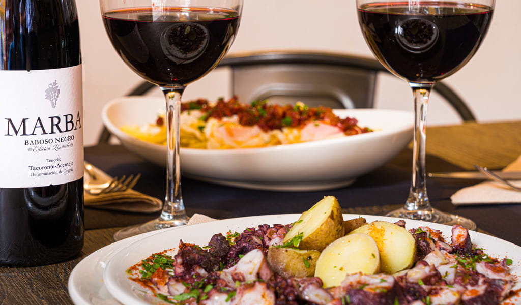 Kartoffeln und Tintenfisch mit Rotweinflasche Marba Tacoronte-Acentejo.