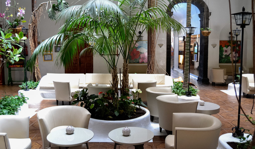 Innenhof mit Palmen, weißen Sesseln und Tischen in einem Café in La Orotava, Teneriffa.