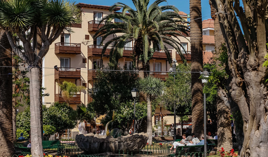 Gebäude mit Balkonen und Palmen im Vordergrund in Puerto de la Cruz, Teneriffa.