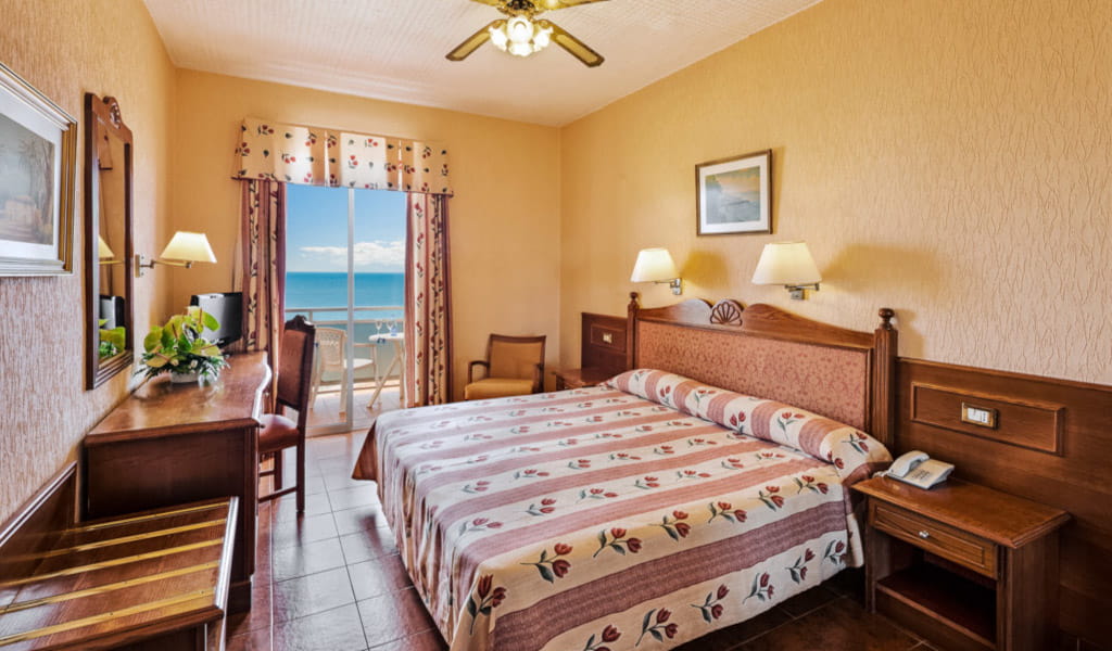 Schlafzimmer mit Doppelbett, Schreibtisch, Balkon mit Meerblick in einem Hotel auf Teneriffa.