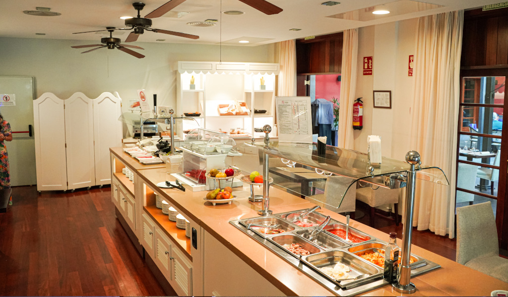 Hotelbuffet-Frühstücksbereich in Tenerife mit Speisenauswahl und Geschirr.