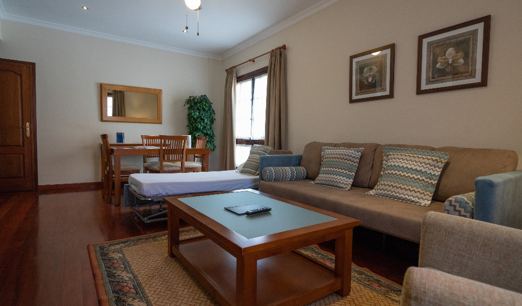 Wohnzimmer mit Sofa, Tisch und Stühlen in einer Ferienwohnung in Tenerife.