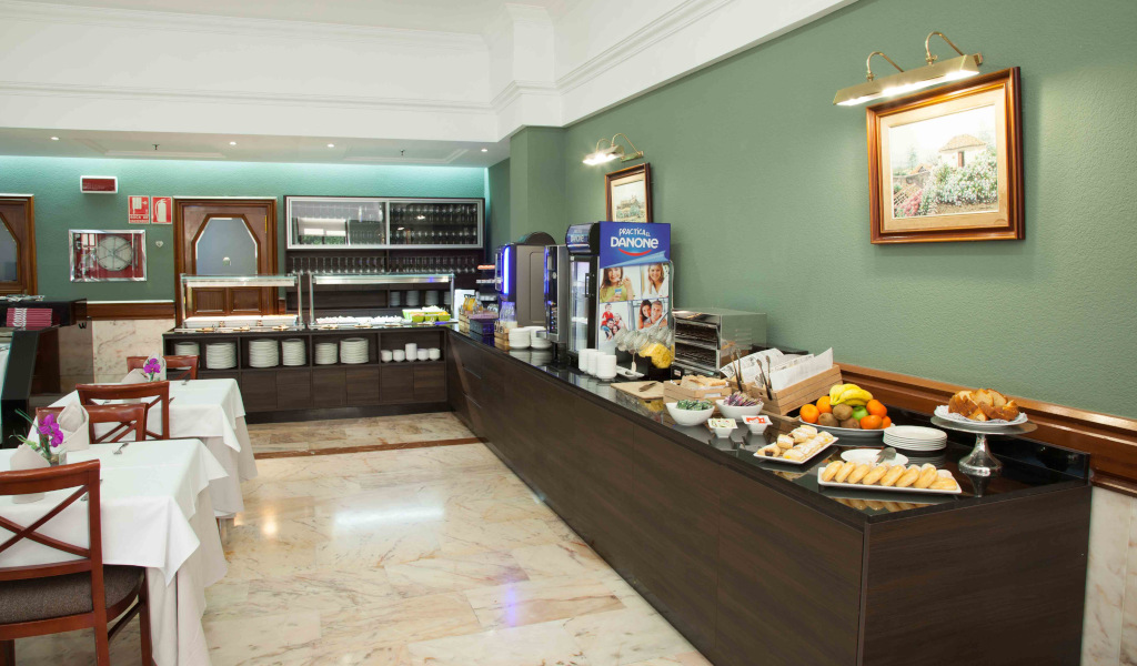 Buffetbereich mit Tischen, Geschirr, Obst und Gebäck in einem Hotel in Tenerife.