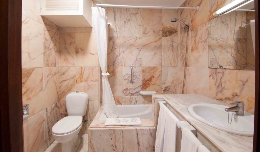 Badezimmer mit Marmorfliesen, Toilette, Waschbecken, Badewanne in Santa Cruz de Tenerife.