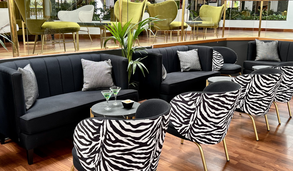 Sitzbereich mit schwarz-weißen Stühlen und schwarzen Sofas in Teneriffa.