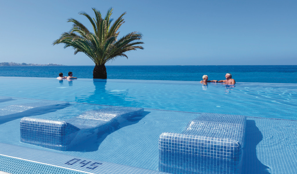 Infinity-Pool mit Palmenblick auf das Meer in Costa Adeje, Teneriffa.