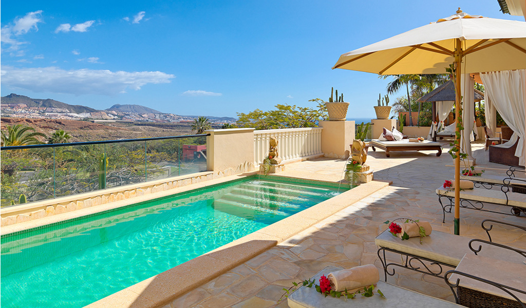 Pool mit Liegestühlen und Sonnenschirmen in Adeje, Teneriffa.