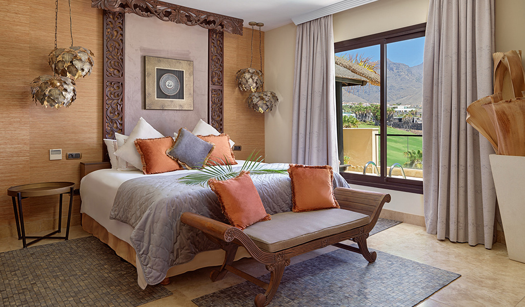 Schlafzimmer mit Blick auf Golfplatz in Teneriffa, dekoriert mit Kissen und Lampe.