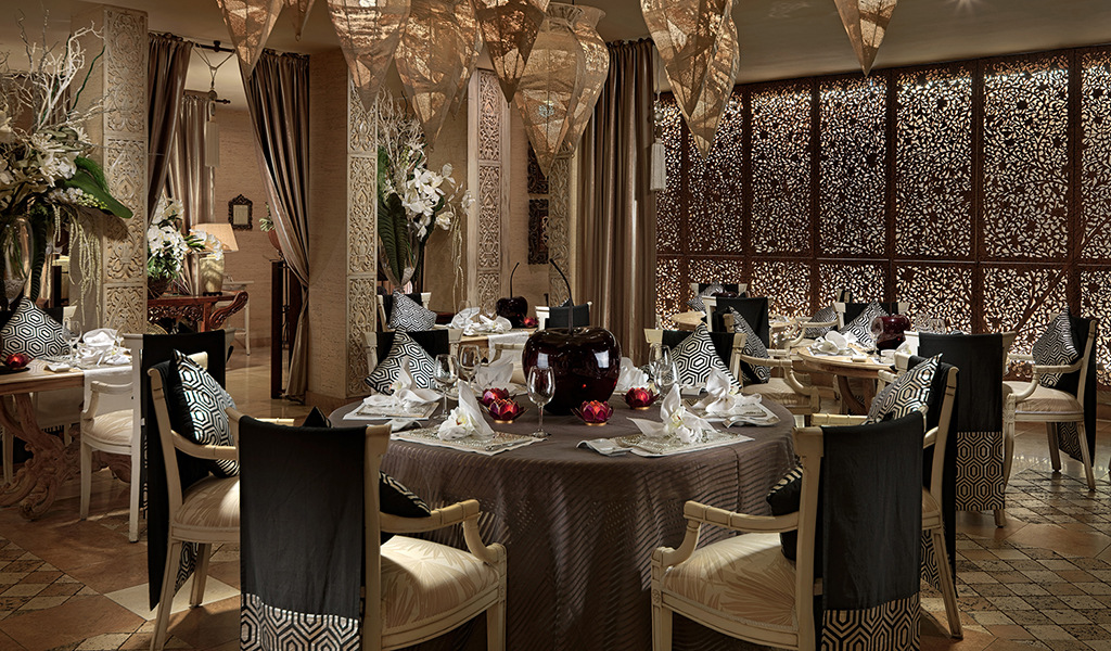 Elegantes Restaurant im Orient-Stil in Teneriffa mit gedeckten Tischen und dekorativen Paneelen.