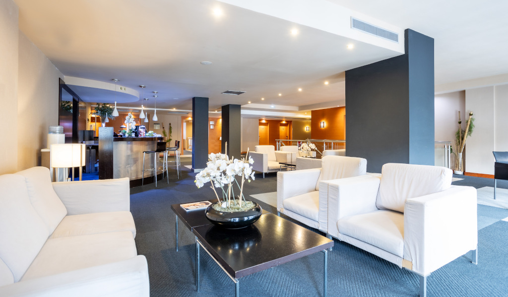 Gemütliche Lobby mit weißen Sofas und Barbereich in einem Hotel in Tenerife.