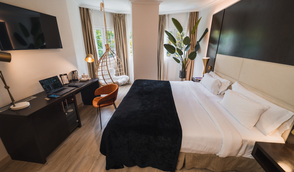 Moderne Hotelzimmer mit großem Bett, Schreibtisch und Fensterblick in Tenerife.