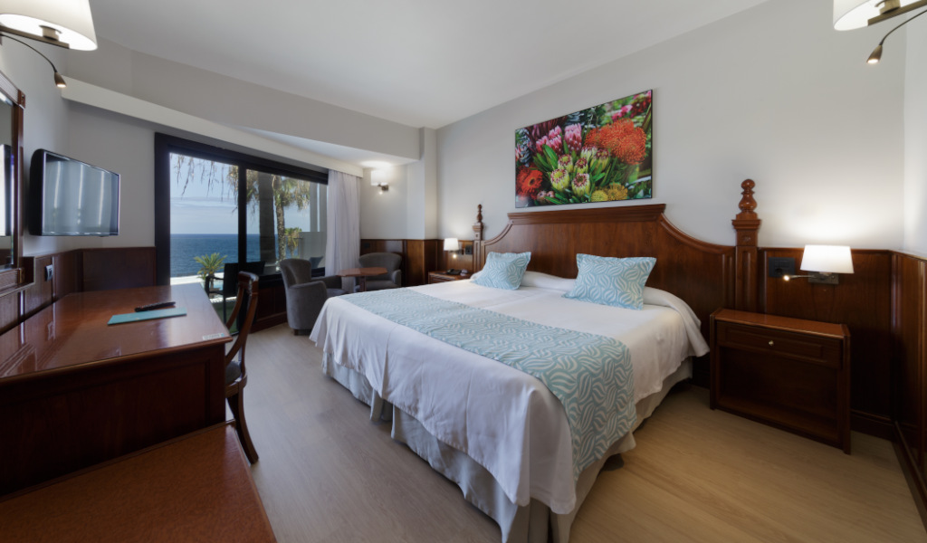 Hotelzimmer mit Doppelbett, Meerblick und Dekor in Puerto de la Cruz, Teneriffa.
