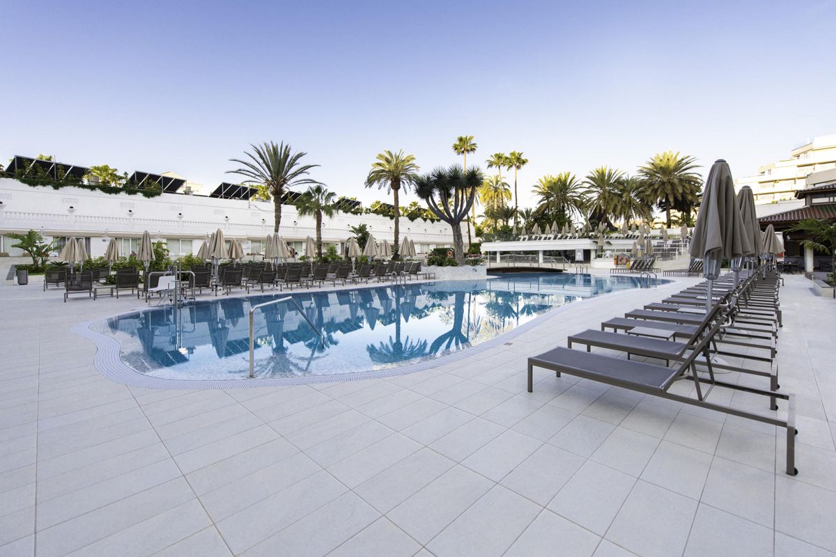 Poolbereich mit Liegen und Palmen im Hotel in Santa Cruz de Tenerife.