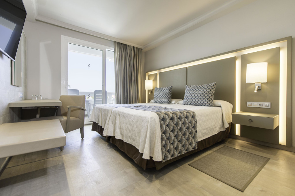 Hotelzimmer mit Doppelbett, Schreibtisch und Balkontür im Ort Los Cristianos, Tenerife.