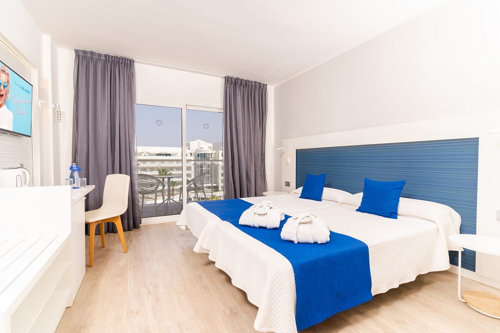 Zwei Einzelbetten mit blauen Kissen in einem Hotelzimmer in Santa Cruz de Tenerife.