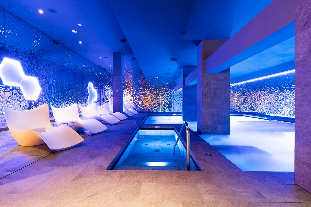 Wellnessbereich mit Liegen und Pool, beleuchtet in blauem Licht in Tenerife.